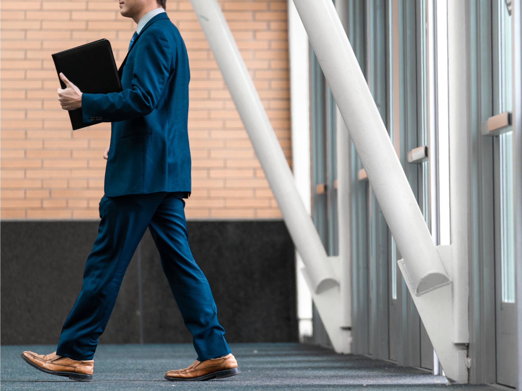 Person in a suit, walking with their resume in hand